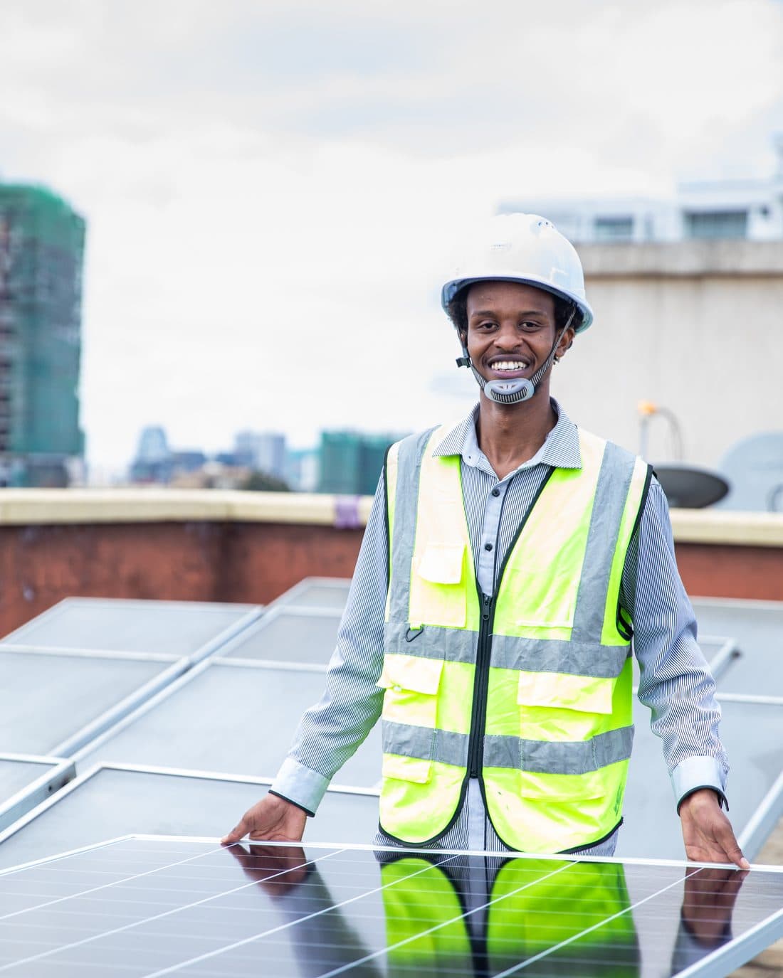 Tesni Energies engineer beside a rooftop solar array in Nairobi